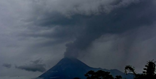 Gambar 1. Panorama puncak Gunung Merapi pada saat erupsi freatik 10 Maret 2014 lalu, diabadikan dari arah selatan oleh pak Bambang Mertani. Nampak kepulan asap menghembus ke atas untuk kemudian menyebar ke arah timur. Nampak pula hujan debu mulai mengguyur di lereng timur. Sumber: Bambang Mertani, 2014. 